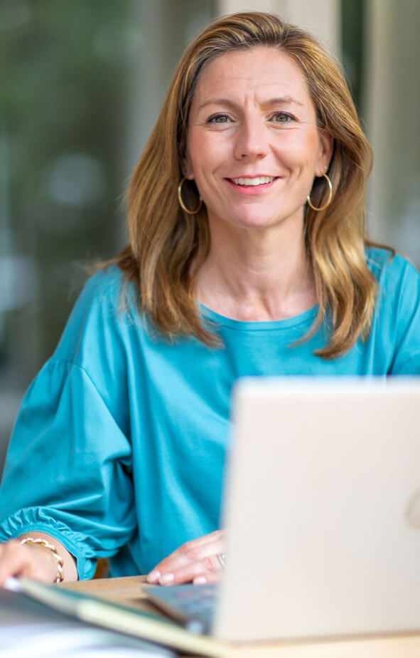 Portrait Josine Opstelten behind laptop